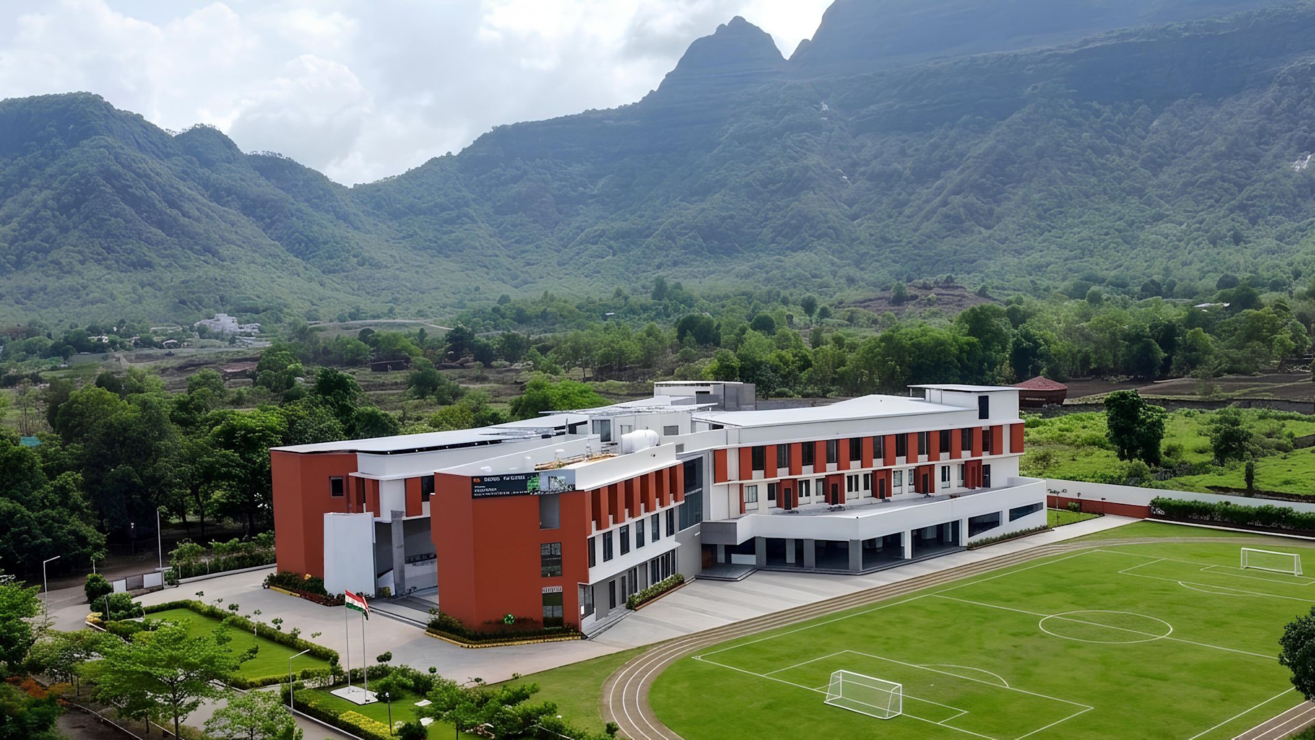 Architectural visual of the upcoming Fr. Agnel School Panvel campus featuring modern academic wings and athletic field set against the Sahyadri mountains